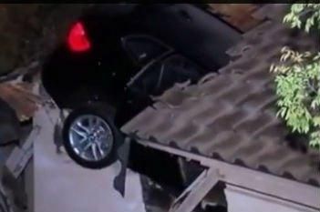 Видеосюжет. В США BMW X5 упал на крышу дома и прошел сквозь нее