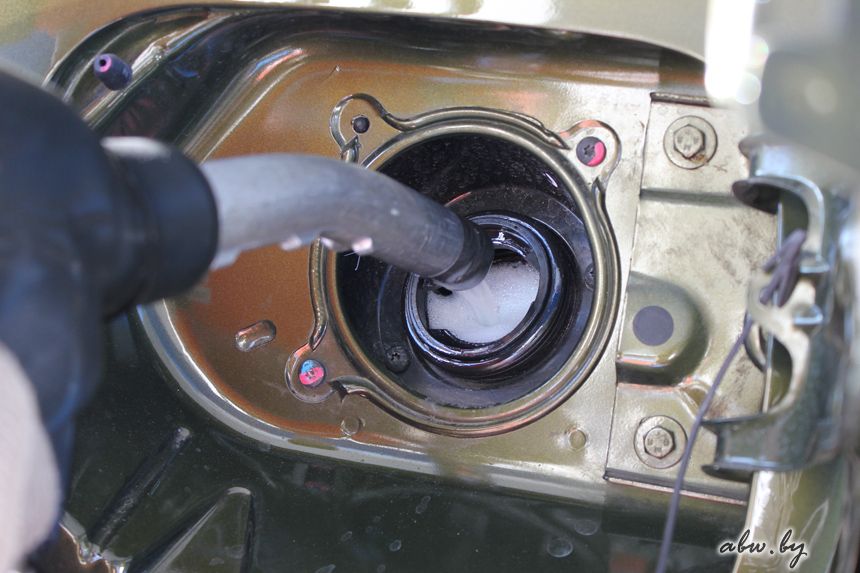 Слить топливо из бака через горловину шлангом. Бензин выплескивается из бака. Топливо выливается из горловины. Автомобильный бензин. Заправка авто.